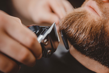 Macro Man hipster having barber shave barbershop hair machine - obrazy, fototapety, plakaty