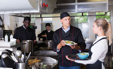 Staff of restaurant with chef working