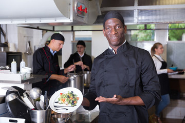 African American chef with cooked dish