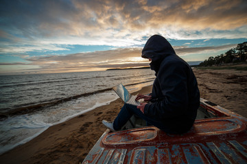Anonymous in the internet. Single programmer or hacker working on the islands beach.