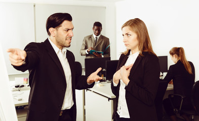 Obraz premium Male boss pointinting to misses in work to woman manager