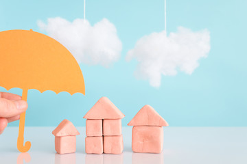 a  Hand holding an umbrella over a house,concept of security and insurance of property