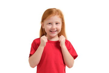 Cheerful little girl, look so excited she is raising her fists up, isolated on white background.