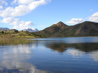 Mountains reflected in rippling peaceful lake waters. Ibón de Tramacastilla (Tramacastilla lake), Huesca, Spain