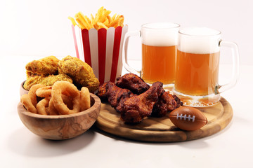 chicken wings, fries and onion rings for football on a table. Great for Bowl Game
