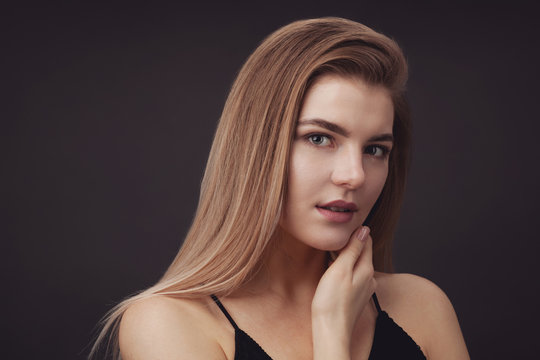 Young beautiful woman against dark background