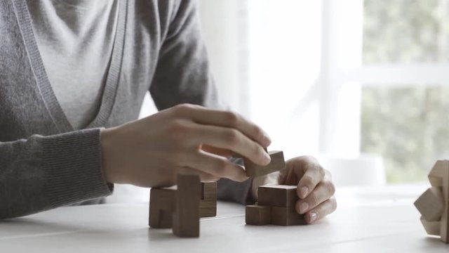 Woman solving an interlocking wooden puzzle