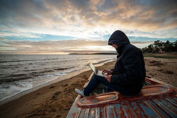Anonymous in the internet. Single programmer or hacker working on the islands beach.