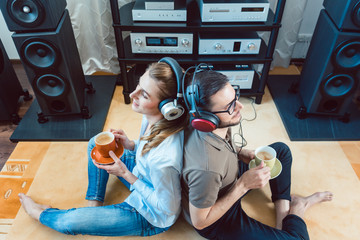 Paar mit Kopfhörer hört Musik von der Stereoanlage 