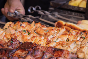 A man fries a barbecue of pork meat and a grill on the back of the chicken meat