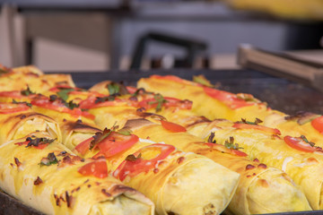 Shawrma arabic food in pita bread is sprinkled with greens and vegetables at the festival of street food