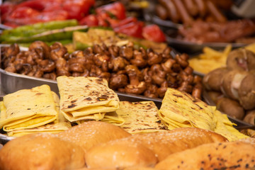 A plate of khachapuri in the background of shawarma and fried mushrooms