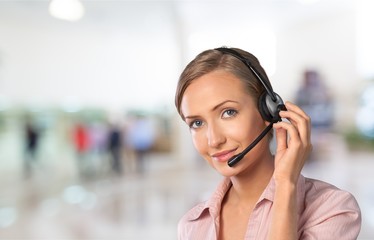 Young female phone service manager on blurred office background