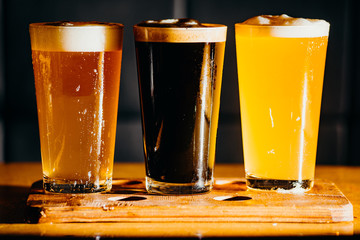 Glasses of light and dark beer in a pub. Dark background.