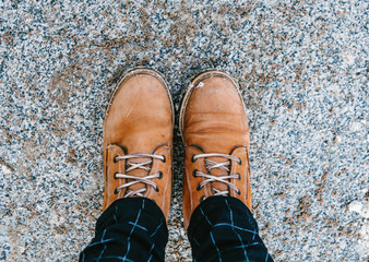 Vintage pair of yellow work and hiking boots advancing on sandy road