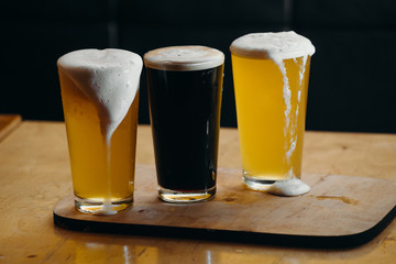 Glasses of light and dark beer in a pub. Dark background.