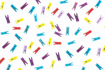 Colored clothes pegs on white background