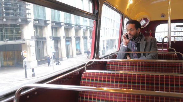 Man sits in an old London bus while travelling through the city