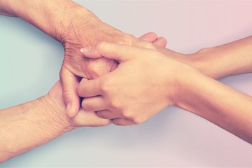 Fototapeta premium Hands of the old man and a young woman. close up.
