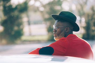 Fashionable black man wearing red jacket and hat