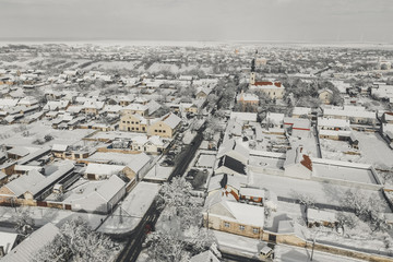 Aerial drone view of town covered with snow. Roads and houses in winter from a bird eye view.