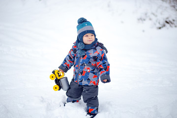 Cute young boy with his toy at winter day