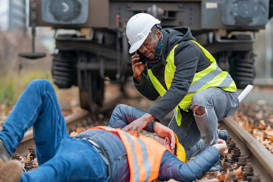 Railroad Engineer Injured In An Accident At Work On The Railway Tracks. Calling For Help