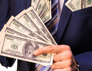 A man in an expensive jacket that is packed with money on white background.Concept on corruption in...