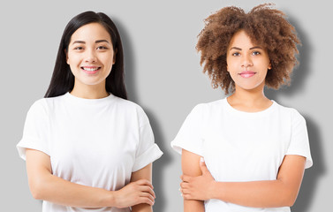 Asian and african american girl in blank template t shirt isolated on gray background. Women in tshirt with copy space and mock up for advertising. White shirts. Front view