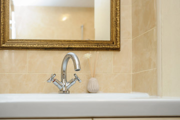 silver faucet mixer on a white sink in a beautiful bathroom