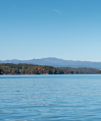Fototapeta na wymiar Calm lake with Mountains in the distance. Lake during the fall season.