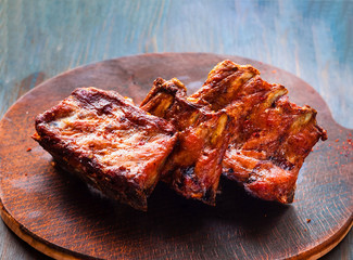 Spicy hot grilled spare ribs from BBQ served  on wooden board . 