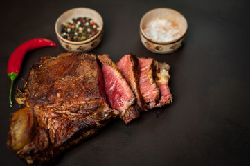 delicious steak, seasonings, a delicious piece of meat, cooked dinner on a concrete background