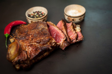 delicious steak, seasonings, a delicious piece of meat, cooked dinner on a concrete background