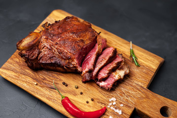 delicious steak, seasonings, a delicious piece of meat, cooked dinner on a concrete background