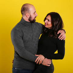 young sexy couple models in hugs in love smile and happy on yellow background , isolated on yellow , love ,couple 