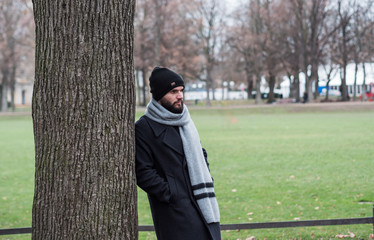 young boy with beard and hat alone in a park
