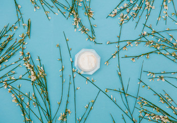 Cream with flowers on blue background