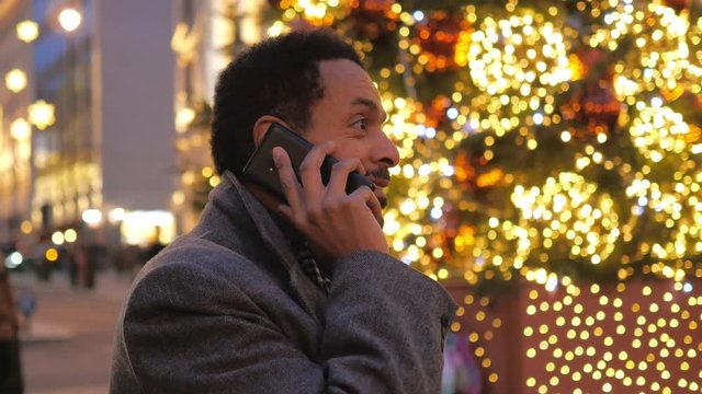 Man takes a phone call in the Christmas decorated city of London