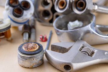 Old faucet for repair. Used hydraulic parts. Light background.