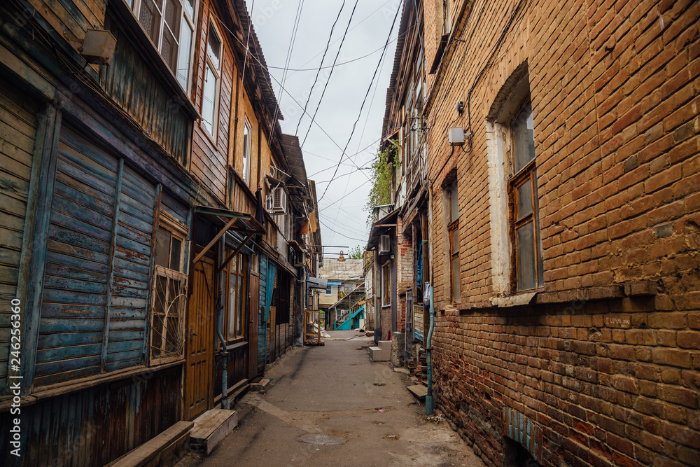 Wall mural Narrow street in old poverty part of Astrakhan city in Russia