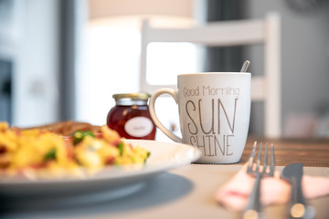 In the morning covered breakfast table with fresh Rüheiern, ham and coffee in the kitchen prepared