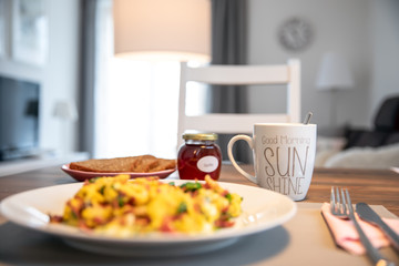 Am Morgen gedeckter Frühstückstisch mit frischen Rüheiern, Schinken und Kaffee in der Küche...