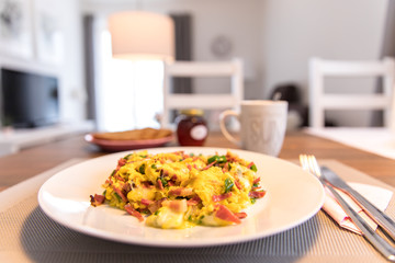 In the morning covered breakfast table with fresh Rüheiern, ham and coffee in the kitchen prepared
