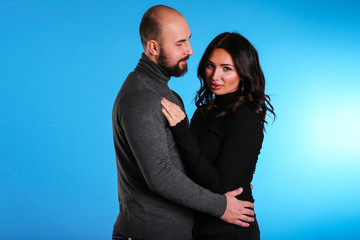 young sexy model couple on blue background in hugs sling and happy 