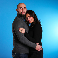 young sexy model couple on blue background in hugs sling and happy 