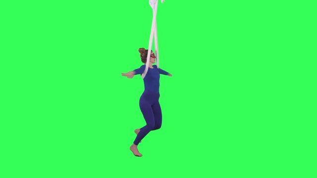 Acrobatic Tissue Artist spinning performs wearing a blue suit over a green screen