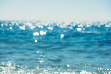 Naklejka na ściany i meble Abstract bokeh background of summer blue sea water at the beach