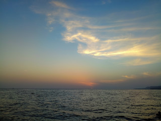 Amazing sea sunset on the pebble beach, the sun, waves, clouds