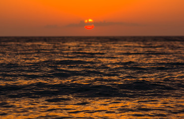 Amazing sea sunset on the pebble beach, the sun, waves, clouds